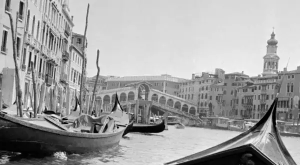 Gondole a Venezia, un classico scatto di Inge Morath. Il Ponte di Rialto sullo sfondo, con edifici storici e il Canal Grande.
