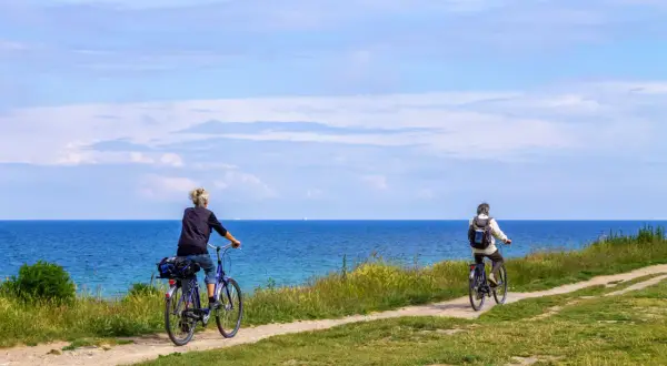 Dwie osoby na rowerach przemierzają malowniczą trasę rowerową R10 nad Bałtykiem.