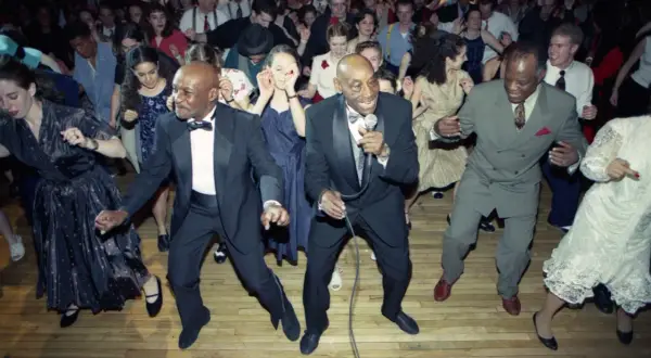 Ballerini in abiti eleganti si scatenano al ritmo della musica swing.