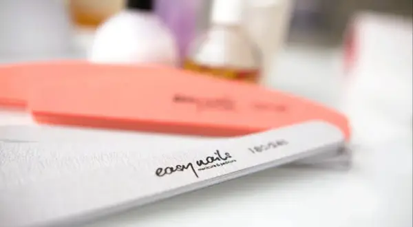 Pilniki do paznokci, jeden pomarańczowy, drugi biały z napisem "easy nails manicure & pedicure". Idealne do wykonania japońskiego pedicure.