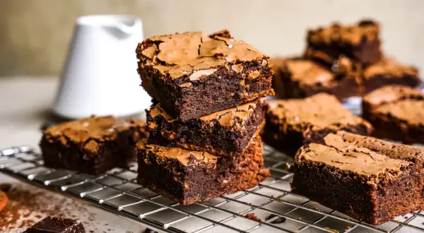 Gestapelte, saftige Brownies auf einem Gitter, bereit zum Genießen. Dieses Brownie-Rezept ist ein Traum für jeden Schokoladenliebhaber.