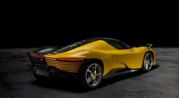 Żółty Ferrari Daytona z czarnym dachem i detalami, prezentujący swoje sportowe linie na ciemnym tle.
