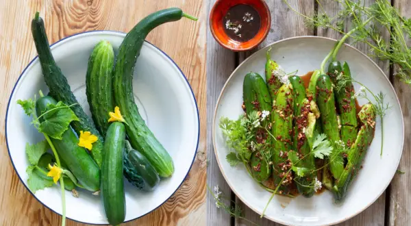 Färska gurkor i en skål och en tallrik med kryddig asiatisk gurksallad, garnerad med örter och blommor.