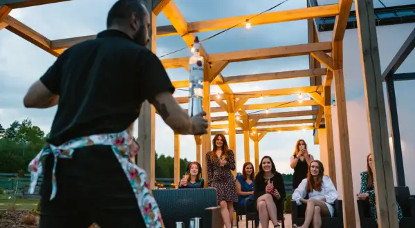 Barman przygotowuje drinki dla grupy kobiet. Świetne, tanie pomysły na wieczór panieński pod gołym niebem.