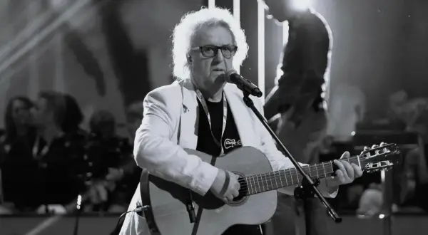 Kto śpiewał "Zegarmistrz światła purpurowy"? To on, z gitarą i charakterystyczną fryzurą, na scenie.