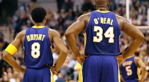 Kobe Bryant (8) i Shaquille O'Neal (34) w strojach Lakersów, czekają na rozpoczęcie meczu. Ile trwa mecz koszykówki? Zwykle 4 kwarty po 12 minut.