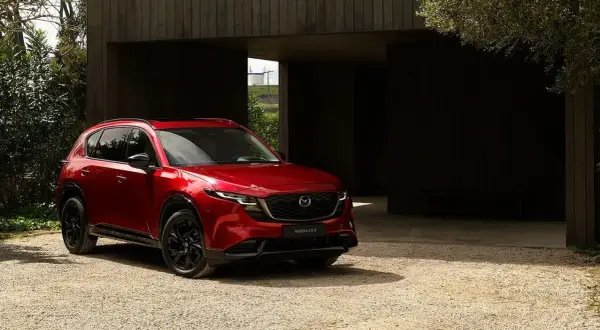 Czerwona Mazda CX-5 na żwirowym podjeździe. Sprawdź aktualną mazda cx-5 cena i wybierz swój wymarzony SUV.
