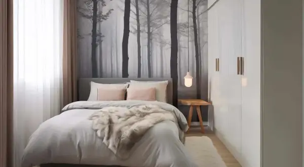 Ein sehr kleines Schlafzimmer einrichten: Gemütliches Bett mit Fell, Waldtapete und weißem Kleiderschrank.