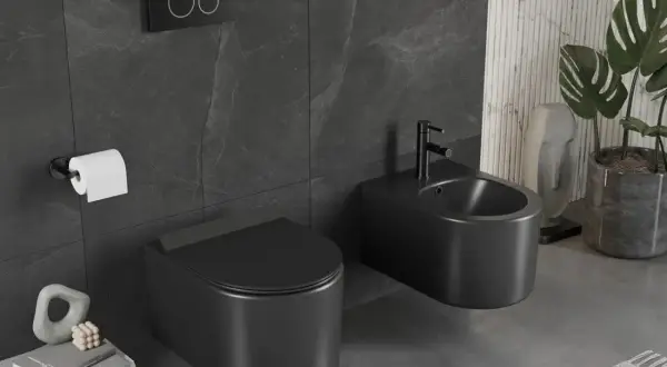 Nowoczesny wc kompakt w matowej czerni, obok bidet, na tle ciemnych płytek. Elegancka łazienka.