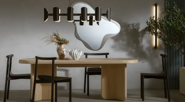Nowoczesna jadalnia z drewnianym stołem, czarnymi krzesłami i designerską lampą. Ile lamp nad stołem w jadalni? Jedna wisząca.