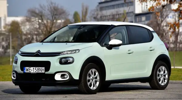 Jasnozielony Citroen C3 z białym dachem, na którym opony wyglądają na zimowe. Idealny do miasta, ale jakie opony wybrać na dalsze trasy?