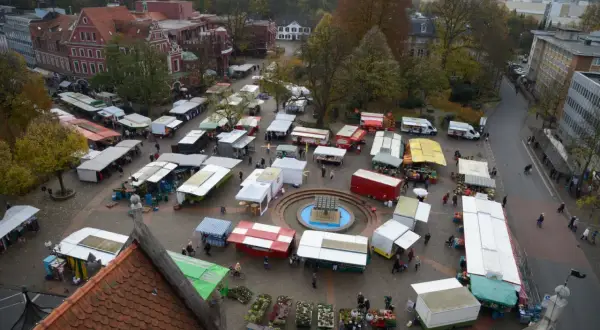 Bunter Markttag auf dem Marktplatz Bergisch Gladbach mit vielen Ständen, Bäumen und Gebäuden im Herbst.
