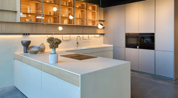 Cocina moderna con isla central, gabinetes de madera y acero inoxidable, y hornos integrados. Diseños cocinas minimalistas y elegantes.