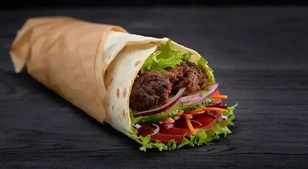Pyszny kebab z kurczakiem, pełen świeżych warzyw i soczystego mięsa. Idealny na szybki posiłek, z myślą o kaloriach.