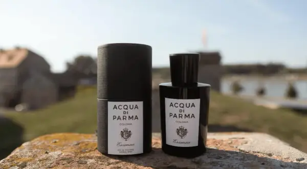 Elegancka butelka i opakowanie Acqua di Parma Essenza na tle malowniczego krajobrazu.