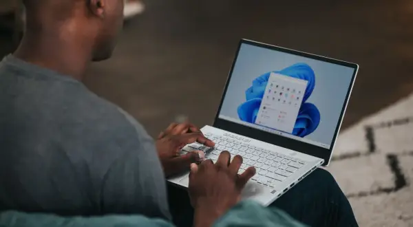 Mężczyzna pisze na laptopie z systemem Windows 11. Chcesz wiedzieć, jak zmienić nazwę użytkownika Windows 11?