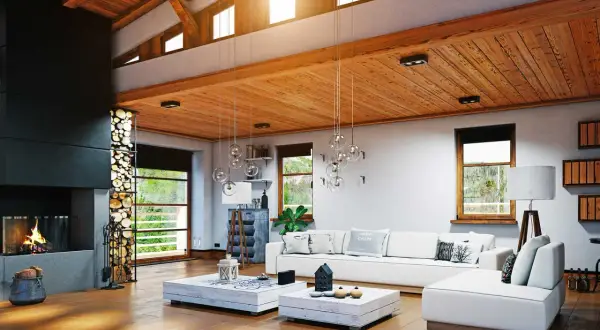 Accogliente soggiorno in una casa di campagna moderna, con camino, divano bianco e soffitto in legno.