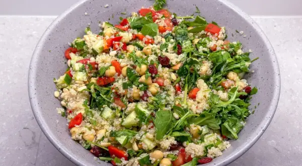 En fräsch och färgglad quinoasallad med kikärtor, gurka, tomat och örter. Ett perfekt quinoa recept för en lätt lunch.