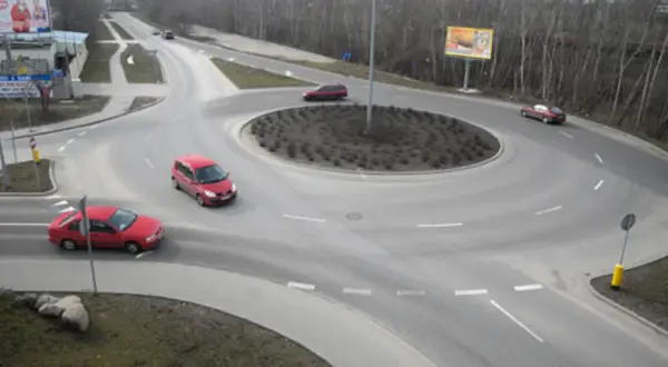 Rondo turbinowe jak jeździć: czerwone samochody płynnie poruszają się po rondzie, pokazując zasady ruchu.