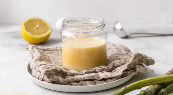 Cremige Sauce Hollandaise im Glas, zubereitet mit dem Thermomix. Dazu Zitrone und Spargel.