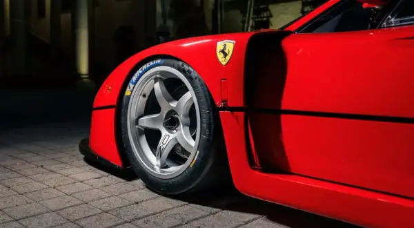 En röd fransk sportbil, en ikonisk Ferrari F40, med sitt legendariska häst-emblem och Michelin-däck.