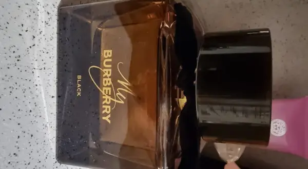 Elegancka butelka perfum My Burberry Black z czarną wstążką i złotym napisem.
