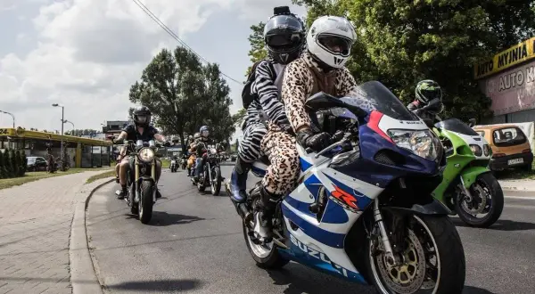 Grupa motocyklistów w nietypowych strojach jedzie ulicą.