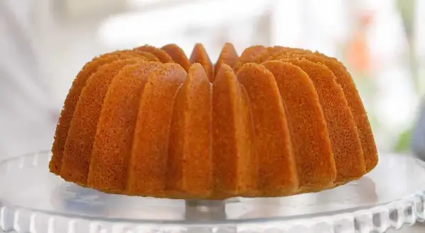 En gyllene, fluffig sockerkaka i en vacker form, redo att avnjutas.
