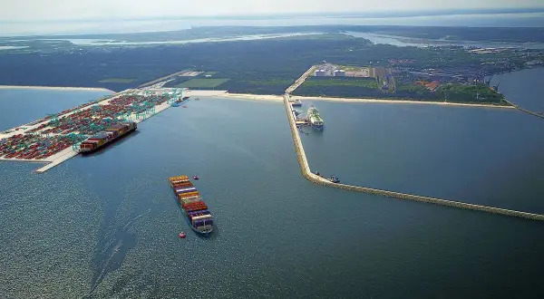 Ogromny port kontenerowy w Świnoujściu z wieloma statkami i dźwigami. W oddali widać terminal LNG.