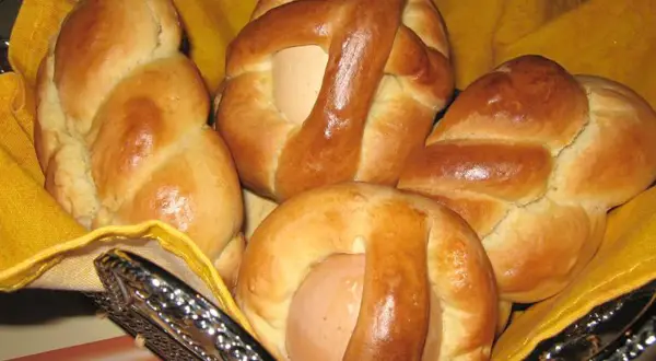 Cuzzupe calabresi morbide, dolci pasquali con uova, in un cestino foderato di giallo.