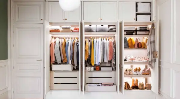 Un armario organizado es un sueño. Este proyecto armario muestra ropa colgada, cajones y estantes con bolsos y zapatos.