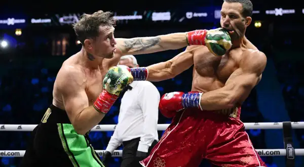 Två boxare i ringen, en träffar den andra i ansiktet. Intensiv action i en misfits boxing-match.