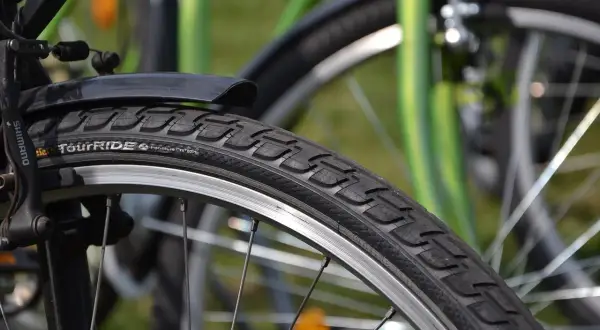 Szukasz informacji, ile kosztuje wymiana opon w rowerze? Zbliżenie na rowerowy bieżnik i obręcz.
