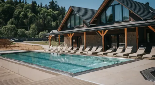 Nowoczesny bieszczady hotel z basenem i leżakami, otoczony zielonymi lasami. Idealne miejsce na relaks.