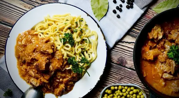Herzhafter Biergulasch mit Spätzle, wie ihn Landfrauen lieben. Dazu Erbsen und Gewürze.