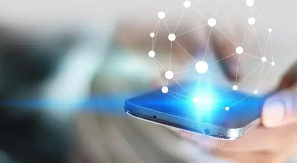 Dłoń trzyma smartfon, z którego emanuje sieć połączeń. Dowiedz się, jak zwiększyć zasięg LTE w telefonie.
