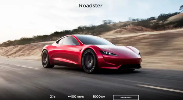 Czerwony Tesla Roadster pędzi po pustynnej drodze, osiągając 100 km/h w 2,1 sekundy.