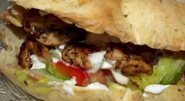 Pyszny kebab w picie z soczystym kurczakiem, świeżą sałatą, pomidorem i kremowym sosem. Idealny na szybki posiłek.