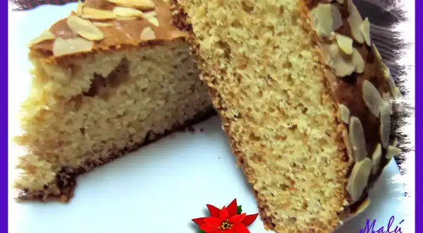 Dos porciones de bizcocho de turrón y yogur, cubiertas con almendras laminadas. Un postre casero delicioso.
