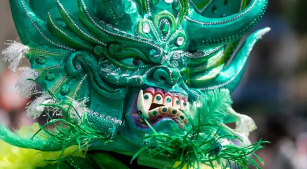 Grüne Maske mit funkelnden Steinen und Federn, ein Blickfang beim Carnival of Cultures Berlin.