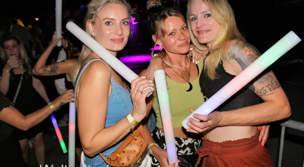 Drei Frauen mit leuchtenden Stäben auf einer Veranstaltung in Herrieden.