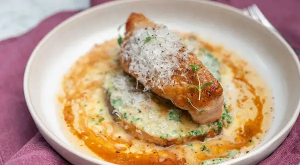 En perfekt lyxig fredagsmiddag: saftig kycklingfilé med krämig sås, toppad med parmesan och färska örter.