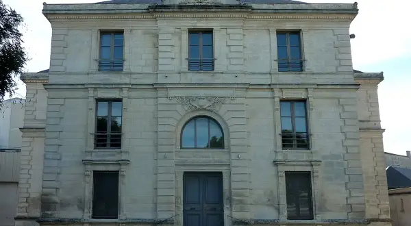 Bâtiment de l'état civil en Charente-Maritime, façade en pierre de taille avec une grande porte centrale et plusieurs fenêtres.