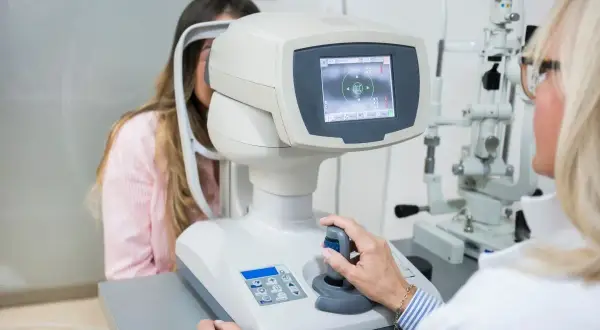 Badanie wzroku pacjentki na nowoczesnym sprzęcie optometrycznym.