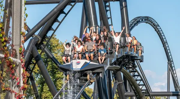 Ludzie na kolejce górskiej w Energylandii, z wodą tryskającą z przodu wagonika. Taka przejażdżka to świetny pomysł na wykorzystanie biletu rocznego Energylandia!