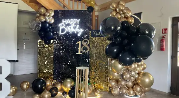 Błyszcząca ścianka z cekinów, neon "Happy Birthday", balony czarne i złote, cyfra 18.