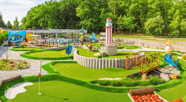 Mini golf w Rewalu to świetna zabawa! Wesołe dekoracje, w tym latarnia morska i rekin, zachęcają do gry.
