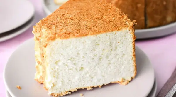 Una fetta soffice di angel cake, con la sua crosticina dorata, pronta per essere gustata.