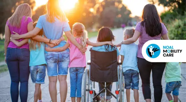 Famiglia unita, con una bambina in carrozzina, esempi di inclusione e superamento della disabilità motoria.
