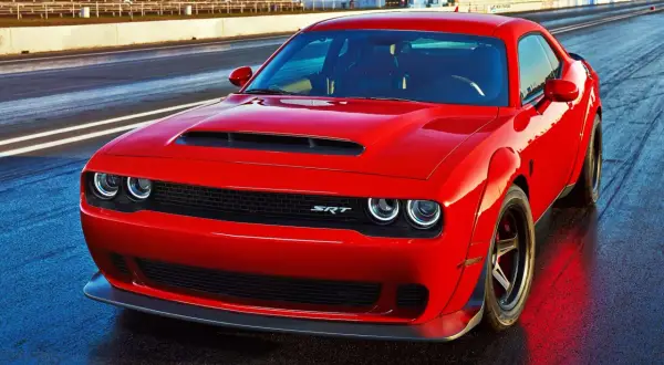 Czerwony Dodge Challenger 5.7 Hemi na torze wyścigowym, gotowy do startu.